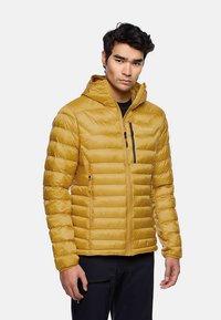 Gelbe, isolierte Jacke mit Kapuze, gesteppter Optik, Reißverschlusstaschen und figurbetontem Schnitt. Hergestellt aus leichtem, glattem Stoff.