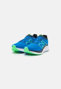 Blauwe sportschoenen met groene accenten, met een gestructureerde bovenkant, zwarte binnenvoering en een rubberen zool in wit en groen.