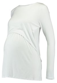 Blusa de maternidade de manga longa branca, feita de tecido macio, com um design de lado franzido para acomodar a barriga e um corte relaxado.