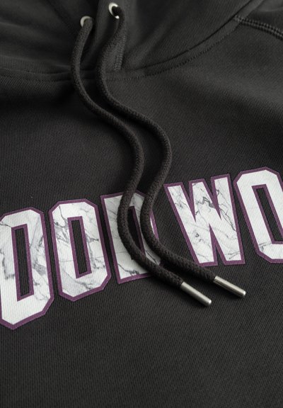 Črna kapuca z belim in vijoličnim napisom "WOOD" z marmornato teksturo. Vključuje temne zategovalce in kovinske aglete.