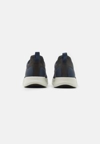Dark blue and black sneakers with textured surface, pull tabs, and a white rubber sole. Rounded shape, sleek design, and minimal detailing.