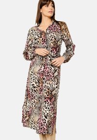 Abito lungo con bottoni in un motivo animalier multicolore, caratterizzato da un colletto, maniche lunghe e una vita legata. Il materiale sembra leggero e liscio.