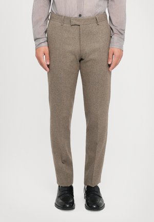 Brown tweed trousers with a tailored fit, featuring a flat front, belt loops, and a textured fabric. Paired with black dress shoes.