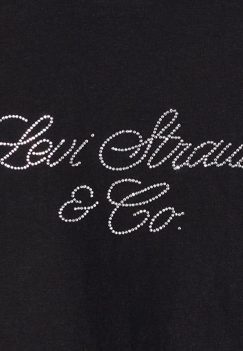 T-shirt en coton noir avec "Levi Strauss & Co." imprimé en strass argentés brillants, avec un design en police cursive.