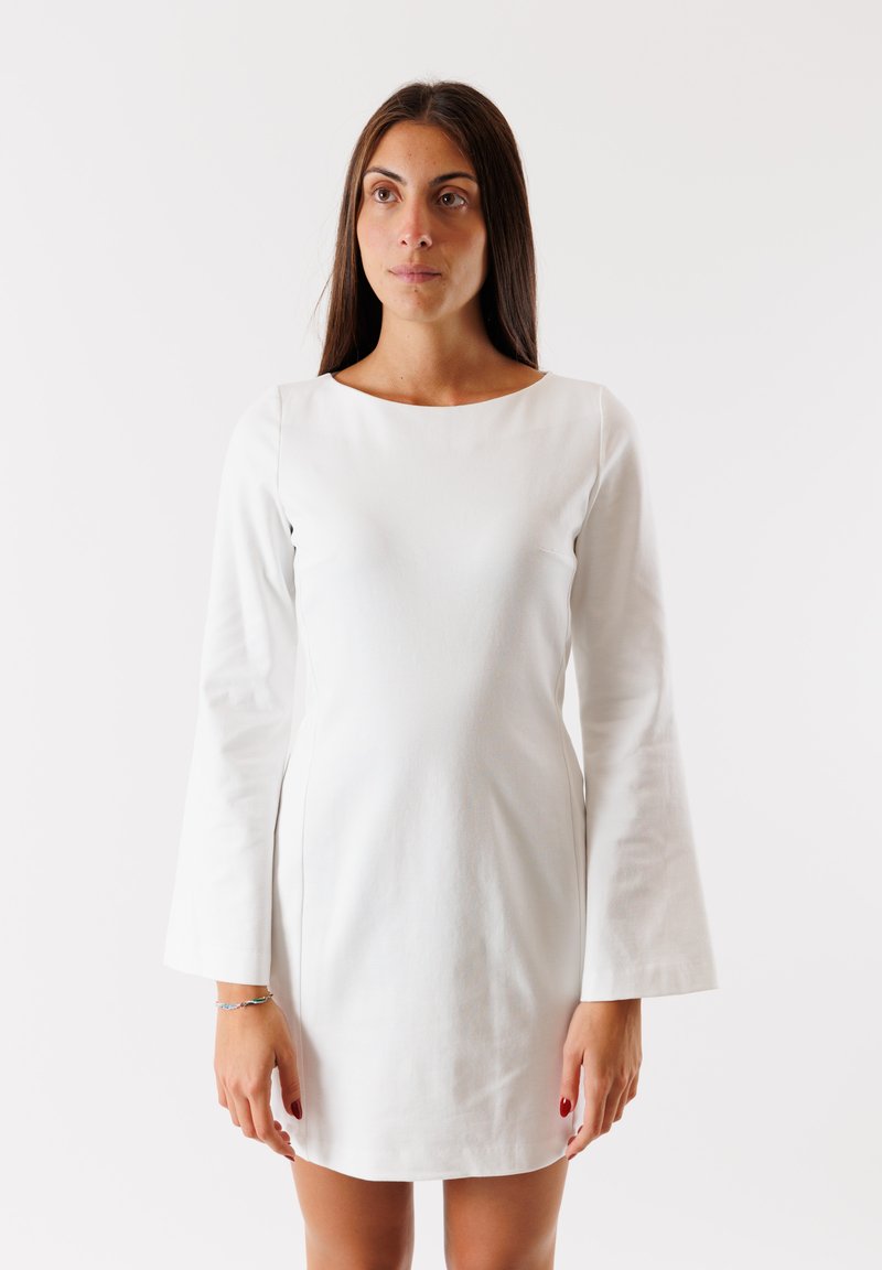 Abito bianco a maniche lunghe con scollatura rotonda. Realizzato in tessuto liscio, presenta una silhouette aderente e maniche svasate. Senza motivi o decorazioni.