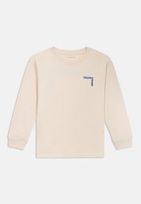 Krémové tričko s dlouhým rukávem vyrobené z bavlny, s malým modrým logem "Calvin Klein" na levé části hrudi. Standardní design s kulatým výstřihem.