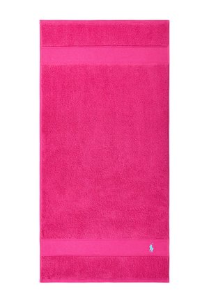 Bright pink rectangular towel with textured bands near the edges and a small light blue embroidered logo in the bottom corner.