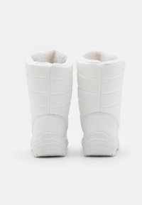 Bottes isolées blanches avec un design matelassé, semelles en caoutchouc texturé et doublure en fausse fourrure pour plus de chaleur. Le style haut offre une meilleure protection.