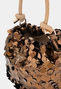Borsa a tracolla marrone con paillettes, con bordi arricciati, dotata di una maniglia metallica e un'etichetta triangolare con la scritta "GUESS U.S.A." in rilievo.