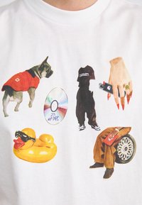 White T-shirt featuring diverse graphics: a dog in a red jacket, a CD labeled “25 WIP TAPE,” a person in dark clothing, a rubber duck, and an accessory.