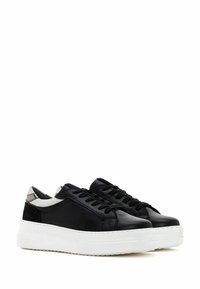 Zapatillas de cuero negro con suelas de goma blanca, que cuentan con un diseño elegante, punta redondeada, cordones negros y un detalle en el talón blanco en contraste.