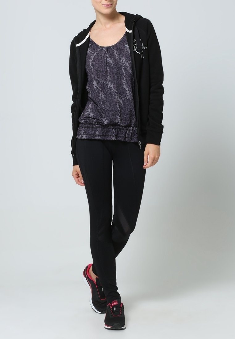 Svart zip-up hoodie, grå mönstrad linne och svarta leggings samt skor med rosa detaljer. Fokus på design och passform för träningskläder.