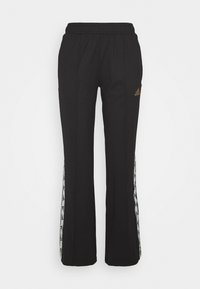 Černé sportovní kalhoty s elastickým pasem. Mají bílé boční panely s logovým vzorem a malé bronzové logo na pravém stehně.