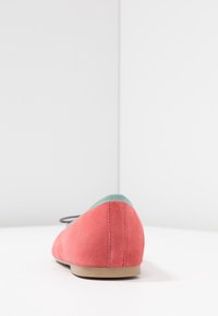 Korallsuede ballerinas med en mintgrön accent på hälen. Har en låg profil och en ljusbrun gummisula.