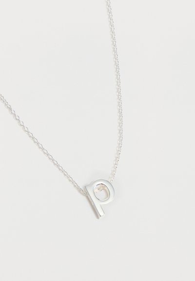 Collier chaîne en argent avec un pendentif en forme de lettre minuscule « p » sur fond blanc uni.
