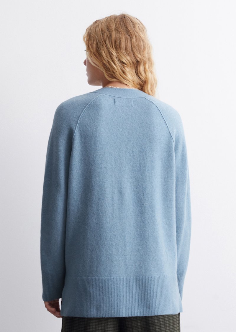 Hellblauer, weicher Strickpullover mit geripptem Saum und Ärmeln. Hat eine lockere Passform und Raglanärmel. Minimale Nähte auf der Rückseite.