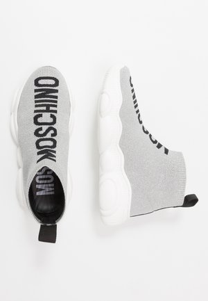 Graue Slip-On Sneaker-Stiefel mit klobigen weißen Sohlen und schwarzem "MOSCHINO"-Text auf dem gestrickten Obermaterial, von oben und von der Seite betrachtet.