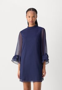 Navy blue shift dress with a high neckline, sheer flared sleeves, and layered ruffle accents at the cuffs, made of lightweight fabric.