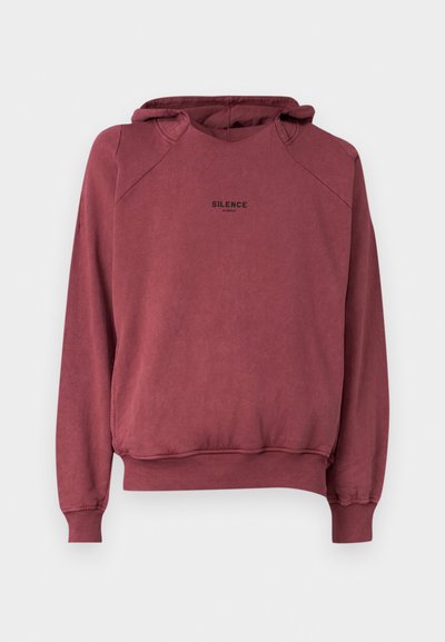 Sweatshirt com capuz em rosa poeira, feito de algodão suave. Apresenta uma bainha arredondada, mangas raglan e texto preto "SILENCE" no peito.