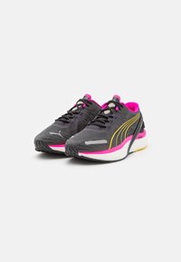 Scarpe sportive grigie, con dettagli in rosa e giallo. Parte superiore in rete con superficie testurizzata, suola in gomma nera e lacci a contrasto.