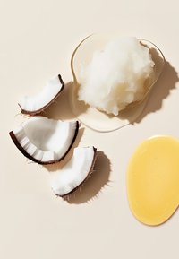Kokosnootschalen, glad witte solide textuur en gele vloeistof op een neutrale achtergrond. Kenmerkt natuurlijke kleuren en organische vormen.