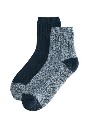 Ein Paar Socken bestehend aus einer einfarbigen dunkelblauen Socke und einer hellblauen Socke mit Sprenkeln, die gummierten Grip-Punkten an der Sohle und gerippten Bündchen hat.