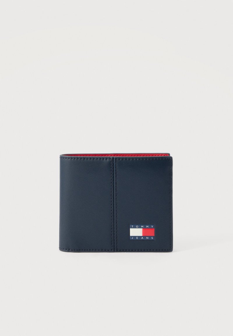 Δερμάτινο πορτοφόλι διπλής αναδίπλωσης σε ναυτικό μπλε χρώμα με κόκκινη εσωτερική επένδυση και ταμπέλα με το λογότυπο Tommy Jeans στο μπροστινό μέρος.