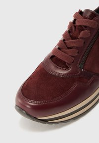 Baskets bordeaux en mélange de daim et de cuir, avec une pointe ronde, un laçage, des coutures discrètes et une semelle beige contrastante.