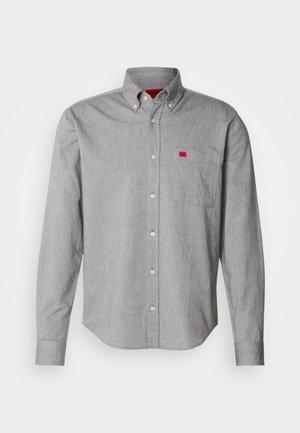 Camisa cinza de botão em tecido de algodão, destacando-se um bolso no peito com um pequeno logótipo vermelho. Textura suave, colarinho estruturado e mangas longas.