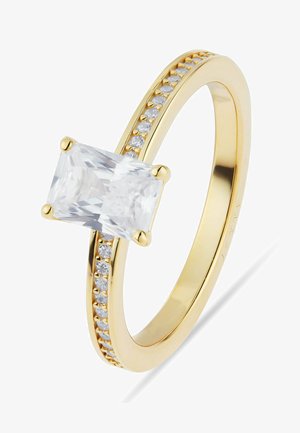 Guld ring med en stor rektangulær klar ædelsten i midten og mindre runde klare sten sat langs ringen.