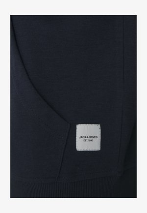 Mørkeblå sweatshirtmateriale med en frontlomme, ribbet kant og et hvidt label med teksten "JACK & JONES EST. 1990." Tekstureret stof.