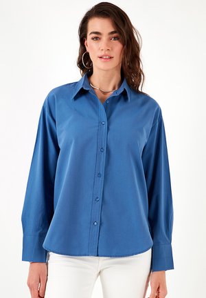 Light blue long-sleeve shirt with button closure, classic collar, and a straight cut, made from smooth fabric with a slight sheen.