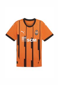 Camiseta de fútbol naranja con rayas verticales negras. Presenta un cuello redondo negro y el logo de Puma; incluye el logo de SCM y el emblema del equipo en la parte delantera.