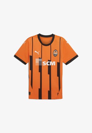 Oranžový futbalový dres s čiernymi vertikálnymi pruhmi. Obsahuje čierny okrúhly výstrih a logo Puma; na prednej strane sa nachádza logo SCM a emblém tímu.