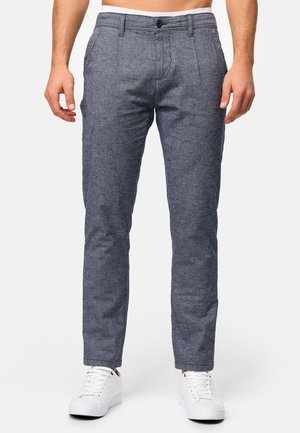 Grå mönstrade byxor med skräddarsydd passform, med en platt frontdesign, bältesöglor och stängning med en knapp, ihop med vita sneakers.