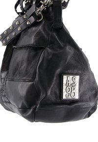 Czarna skórzana torebka o zaokrąglonym kształcie, wyraźnym przeszyciu, teksturowanym wykończeniu i srebrnej tabliczce z logo. Posiada dźwignię z ćwiekami i metalowe akcenty.