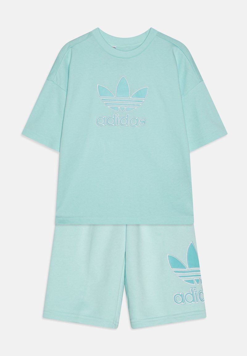 T-shirt Adidas azul claro com um grande logótipo bordado e calções a condizer. Teclado suave, corte descontraído, calções até ao joelho com detalhe do logótipo.