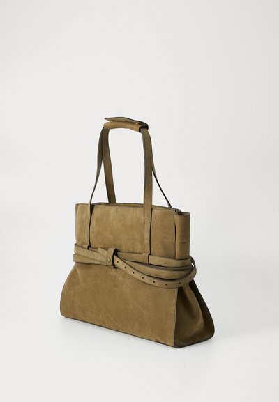 Suède τσάντα χειρός σε ελαιόλαδο πράσινο χρώμα, με δομημένο σχήμα, μακριούς χειρολαβές και λεπτομέρεια με περιτυλιγμένο λουρί γύρω από τη μέση. Μαλακή υφή.