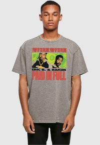 Grijze oversized t-shirt met een voorzijde graphic van twee figuren en de tekst "PAID IN FULL" in vet rood, ronde hals, korte mouwen, casual pasvorm.