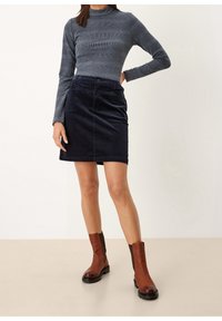 Gonna in corduroy blu navy con vita aderente, chiusura con bottoni frontali e texture liscia. Abbinata a un top grigio a maniche lunghe a coste e stivali alla caviglia marroni.