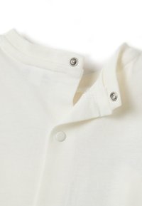 Witte katoenen kraag van kleding met drukknoopsluitingen, met een zachte textuur en een lichte rek, ontworpen voor gemakkelijke draagbaarheid en comfort.