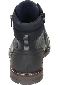 Bota de cuero negra hasta el tobillo con superficie texturizada, forro de fleecy azul oscuro, cierre de cremallera lateral y suela marrón contrastante con costuras.