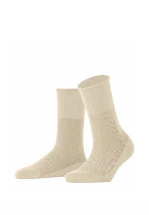 Paar beige knöchellange Socken mit gerippten Bündchen und strukturiertem Strickmuster an Fuß- und Knöchelbereich.