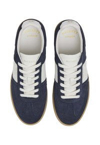 Mornarice tenisice od ante kože s bijelim kožnim detaljima, okrugli vrh, ravni gumeni potplat i bijele vezice. Imaju oznaku "Hackett London" unutra.