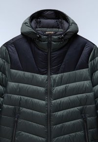 Giacca a vento in verde scuro e nero, con texture trapuntata, cappuccio e zip frontale con tasche laterali. Accentuata da un motivo a chevron.