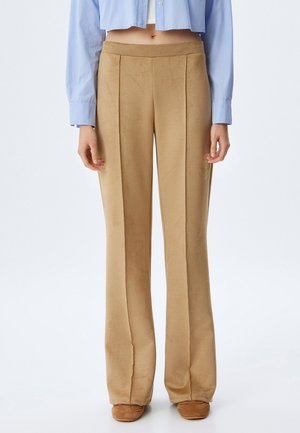 Tan, zachte stof wijde broek met een gladde textuur; heeft twee voorplooien voor extra detail. G dragen met een cropped blauwe blouse.