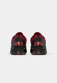 Red athletic shoes with black accents, featuring a breathable mesh upper, padded collar, and a thick rubber sole with cushioning technology.