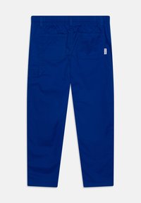 Pantaloni in tessuto elasticizzato blu con vita elastica, due tasche posteriori e una tasca laterale. Texture liscia e vestibilità sartoriale.