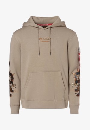 Sweat à capuche beige Alpha Industries avec poche avant, motifs de dragons sur les manches, capuche à cordon et poche zippée avec étiquette rouge sur le bras gauche.