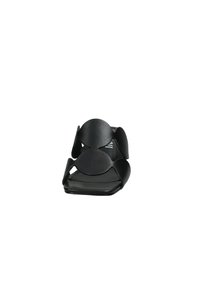 Infradito neri con suola piatta, due ampi cinturini circolari e design aperto per una migliore traspirabilità. Texture liscia con finitura opaca.